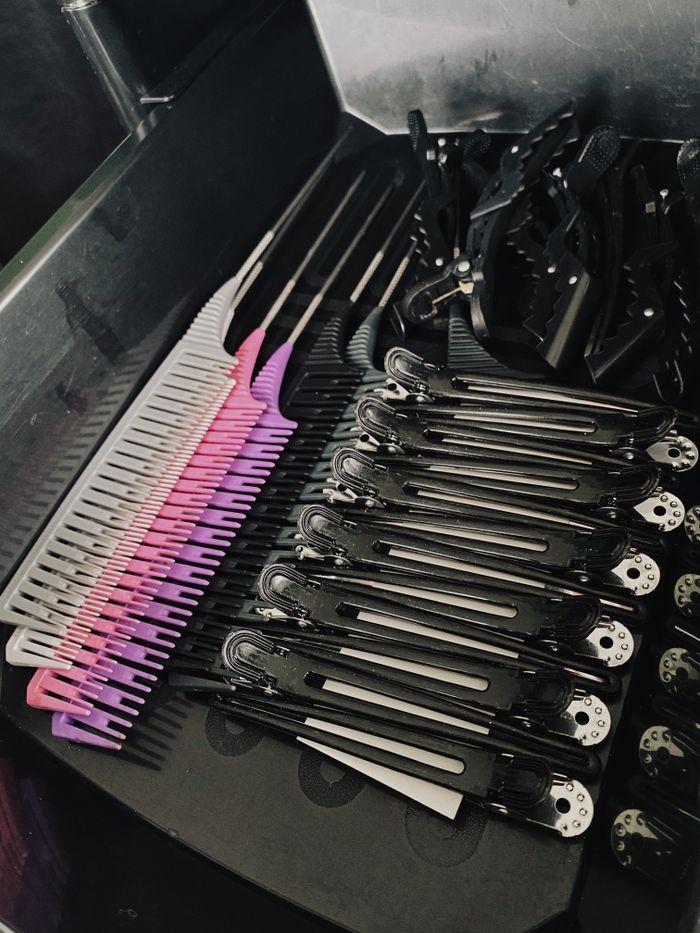 A collection of hair combs and clips neatly arranged in a salon drawer, showcasing a variety of colors and styles.