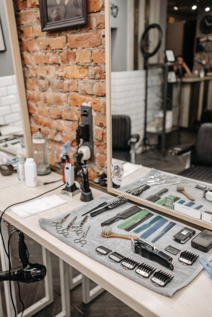 service-01 Neatly arranged barber tools in a stylish salon setting with brick wall.